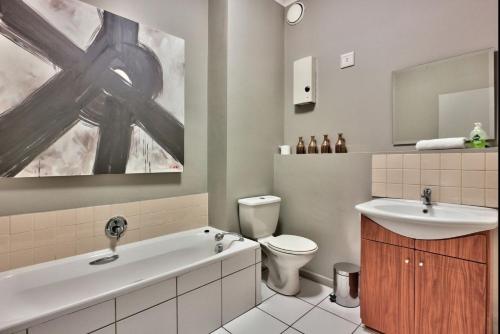 a bathroom with a sink and a tub and a toilet at Designer 1 bedroom Vacation Rental Cape Town in Cape Town