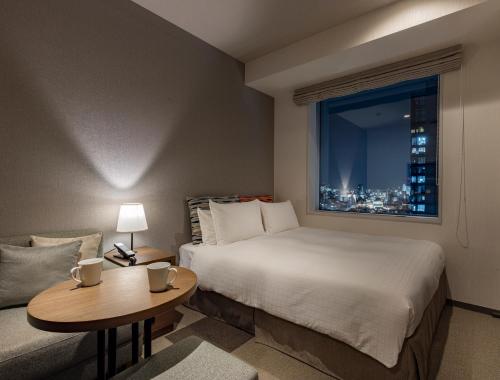 a hotel room with a bed and a window at Tokyu Stay Aoyama Premier in Tokyo