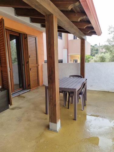 una mesa de picnic de madera en medio de un patio en Casa Alessia, en SantʼAnna Arresi