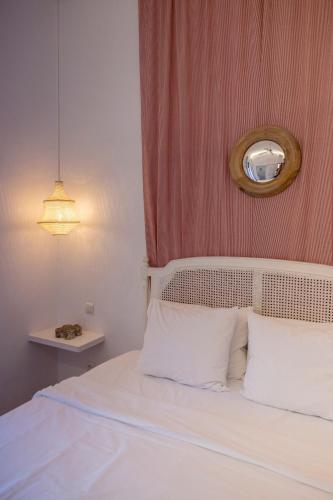 a bedroom with a bed with white pillows and a mirror at La Morada Mas Hermosa in Marbella