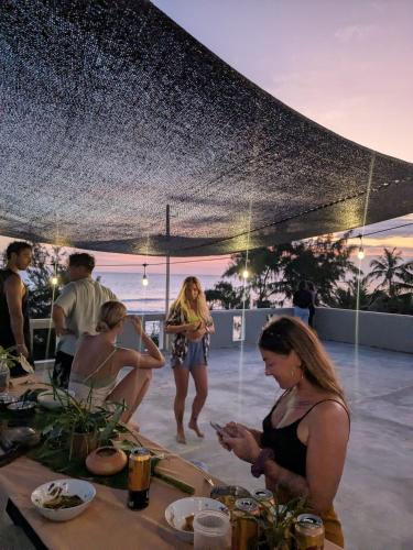 a group of people standing around a table with food at The Stables Oceanfront Hotel Midigama in Midigama