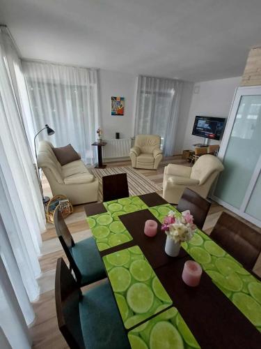 a living room with a table with flowers on it at Villa Vamus Vendég- és RendezvényHáz in Vámosszabadi