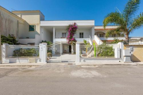 a white fence in front of a white house at Villetta Stella Di Mare by BarbarHouse in Torre Lapillo
