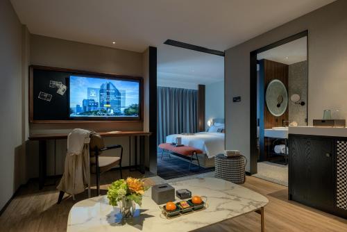 a hotel room with a television and a living room at 林夕元酒店长沙五一广场湘雅附一店 in Changsha
