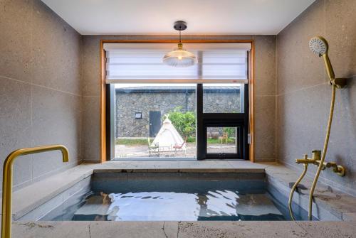 a bath tub in a room with a window at 월영사계 in Seogwipo