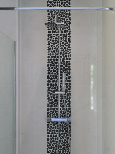 une douche avec une porte vitrée dans une salle de bain dans l'établissement Grande Villa 350 M2, piscine chauffée vue mer et collines, CAVALAIRE sur mer, 10 personnes, à Cavalaire-sur-Mer