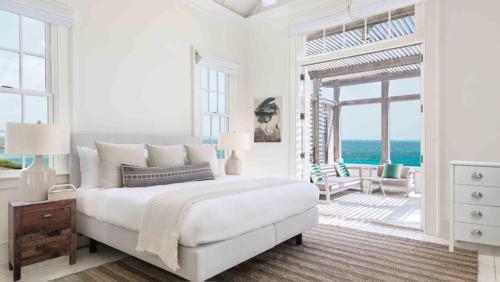 a bedroom with a bed with a view of the ocean at Ambergris Cay - Private Island All-Inclusive in Big Ambergris Cay