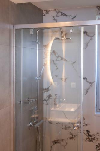 a shower with a glass door with a sink at See2sea Cozy Apartments in Kolymvari