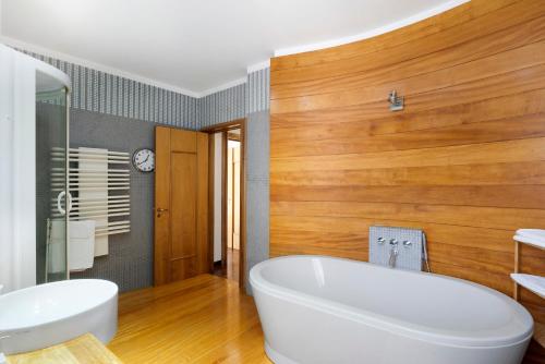 a bathroom with a large white tub and wooden walls at Divina Vietri in Vietri sul Mare
