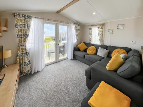 a living room with a couch and a large window at Sandy Paws - Uk45511 in Mainsriddle