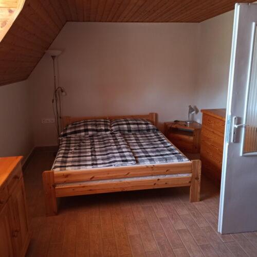 a bedroom with a wooden bed in a room at Kati Appartmann in Balatonberény
