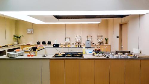 a large kitchen with a counter with food on it at Vyluk Hotel-Xixi Wetland Lingyin Temple West Lake in Hangzhou