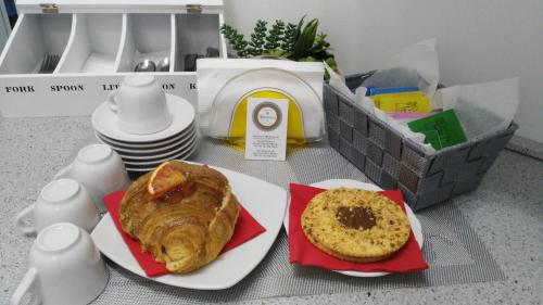 une table avec deux assiettes de nourriture et une pâtisserie dans l'établissement La Suite, à Civitanova Marche