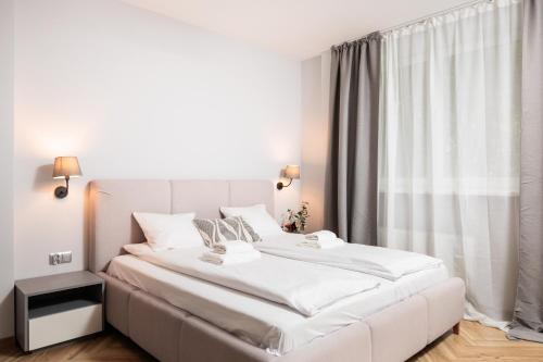 a white bed in a room with a large window at Nowy Hotel Monika - by Upstairs in Kraków