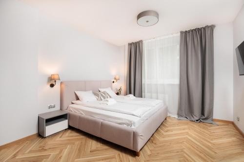a bedroom with a large white bed and a window at Nowy Hotel Monika - by Upstairs in Kraków