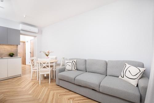 a living room with a gray couch and a table at Nowy Hotel Monika - by Upstairs in Kraków