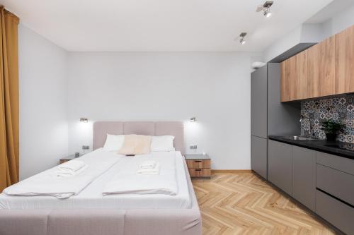 a bedroom with a large white bed and a wooden floor at Nowy Hotel Monika - by Upstairs in Kraków