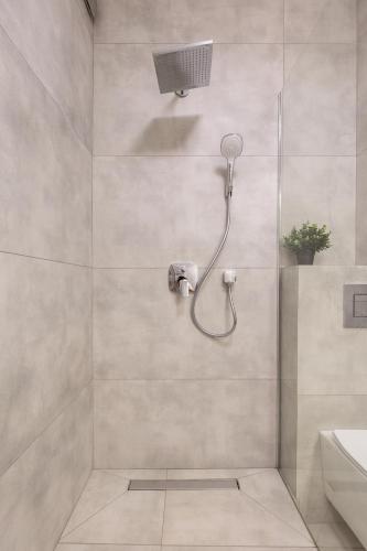 a shower with a shower head in a bathroom at Nowy Hotel Monika - by Upstairs in Kraków