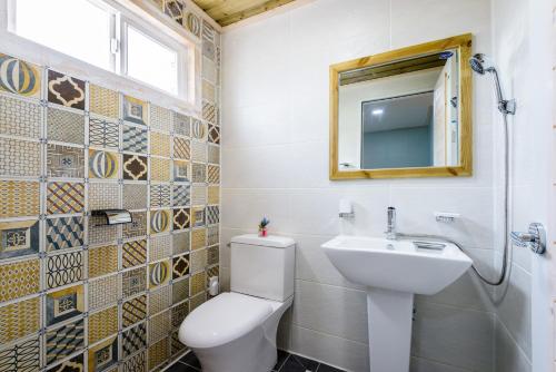 a bathroom with a toilet and a sink and a mirror at White star in Jeju