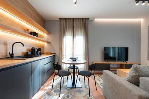 a kitchen and living room with a table and a couch at Nanooq Apartments in Kolašin