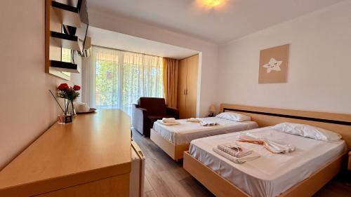 a hotel room with two beds and a chair at Hotel Venus in Mamaia