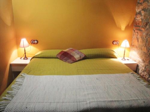 a bedroom with a bed with two lamps on both sides at L'Antic ajuntament de la Torra in La Baronia de Rialb