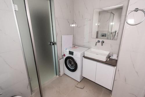 a white bathroom with a washing machine and a sink at Sinani Villas Rhodes - Afantou Private Retreats in Afantou