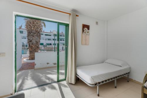 een slaapkamer met een bed en een groot raam bij Alondras Apartamento E107 in Costa Del Silencio