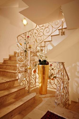 a staircase with a metal railing and a potted plant at Hotel Alpenjuwel 4 Sterne Superior in Tux