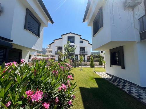 vistas al patio de una casa con flores rosas en Premium Homes, en Didim