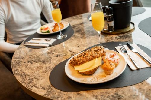 a table with two plates of food and glasses of orange juice at Van der Valk Hotel Gorinchem in Gorinchem