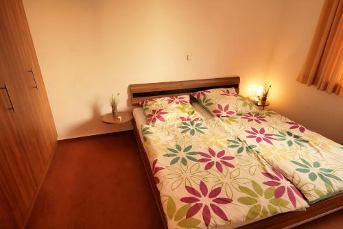 a bedroom with a bed with a floral bedspread at Meerblick 5 - Großenbrode in Grossenbrode