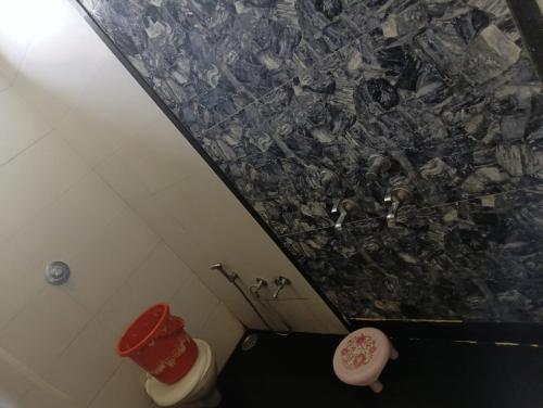 a bathroom with a toilet and a marble wall at LL Guest House in Hinganghāt