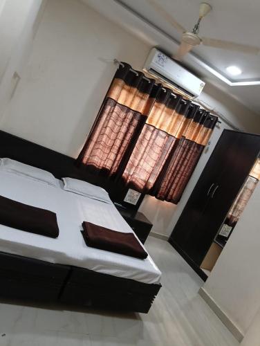 a bedroom with a bed and a window with curtains at LL Guest House in Hinganghāt
