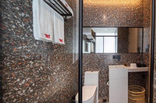 a bathroom with a mirror and a sink and a toilet at Leader Art Hotel（Shenzhen University Science and Technology Park Store)） in Shenzhen
