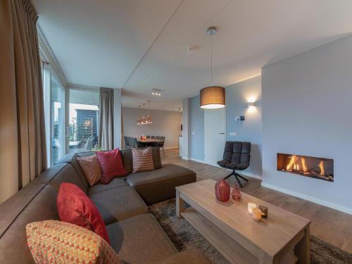 ein Wohnzimmer mit Sofa und Kamin in der Unterkunft Holiday home with whirlpool and sauna in a quiet area in Zeeland in Colijnsplaat