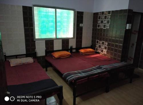 a room with two beds and a window at Himlok Guest House in Kedārnāth
