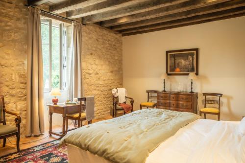 ein Schlafzimmer mit einem Bett und einem Tisch und Stühlen in der Unterkunft Domaine de Prunget - Pierres d'Histoire in Tendu