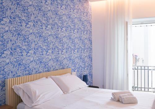 a bedroom with a bed with blue wallpaper at Marina Palace Apartments & Terrace in Lipari