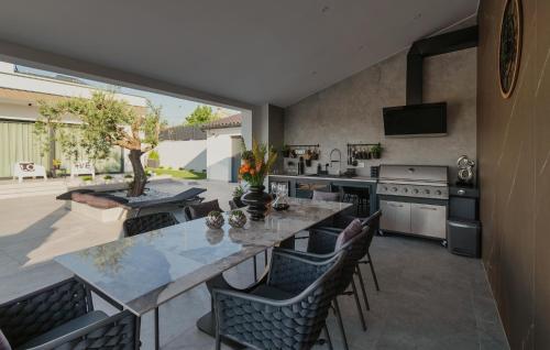 a kitchen with a large table with chairs and a counter at Gorgeous Home In Momjan With Sauna in Momjan