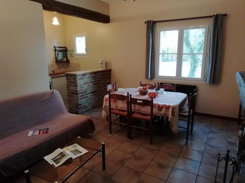 a living room with a table and a couch at Charming Chalet with Swimming Pool in Quend in Quend