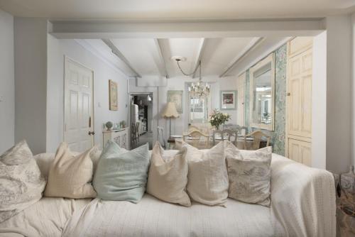 a living room with a white couch with pillows at Almond Cottage - Pets welcome - Free Parking - Garden in Hayle