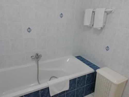 a bathroom with a tub and a toilet and towels at Charming Chalet with Swimming Pool in Quend in Quend