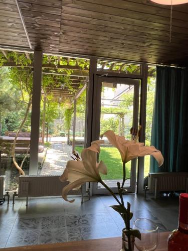 a room with large glass doors and a flower in a vase at ДЗЕН Garden in Fontanka