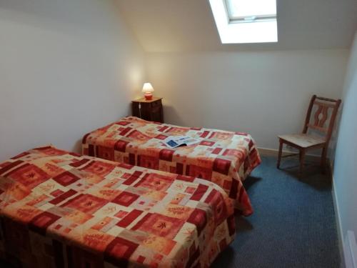 a hotel room with two beds and a chair at Charming Chalet with Swimming Pool in Quend in Quend