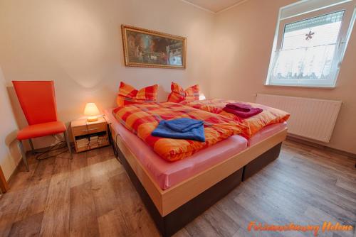 ein Schlafzimmer mit einem Bett und einem roten Stuhl in der Unterkunft Helene in Hüttenrode