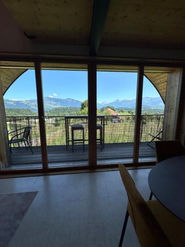 a room with a large window with a view of the mountains at Panormamablick, NH Spiez, 10 min vom Thuner See in Reutigen