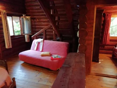 a living room with a pink chair in a cabin at Charming Chalet with Swimming Pool in Quend in Quend