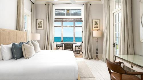 a bedroom with a bed and a view of the ocean at Ambergris Cay - Private Island All-Inclusive in Big Ambergris Cay