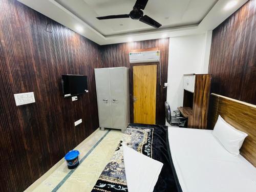 a bedroom with wooden walls and a bed and a tv at Laxmi Inn Guest House in New Delhi